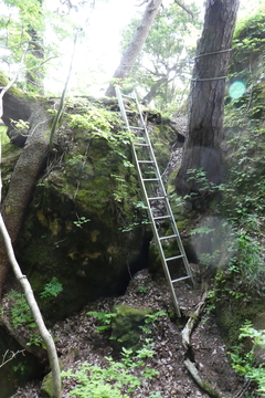 洞窟の前にハシゴがかけられた展望岩へ