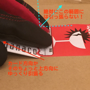 カードについたシールを剥がれない様に抑えながら引っ張る